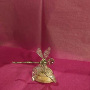 Dragonfly on rock pink background